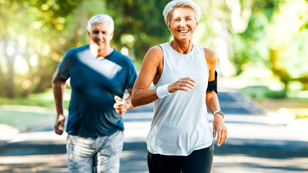 Older couple jogging together in a park, a healthy aging routine behind the NMN vs NAD+ question